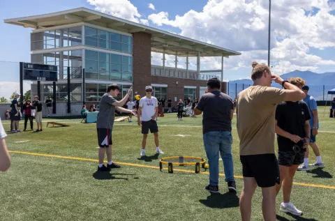 People playing spike ball on a turf field.